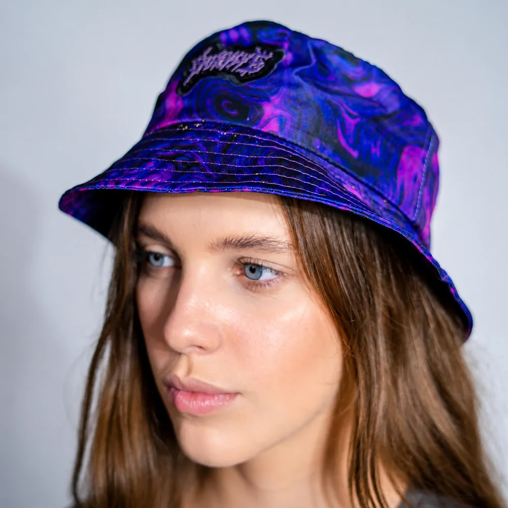 Modelo usando chapéu bucket roxo com estampa na peça inteira e aplicação em alto relevo na frente
